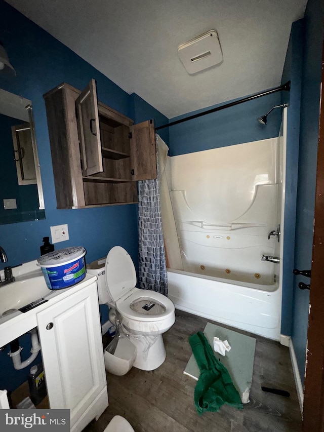 full bathroom with shower / tub combo with curtain, wood-type flooring, toilet, and vanity