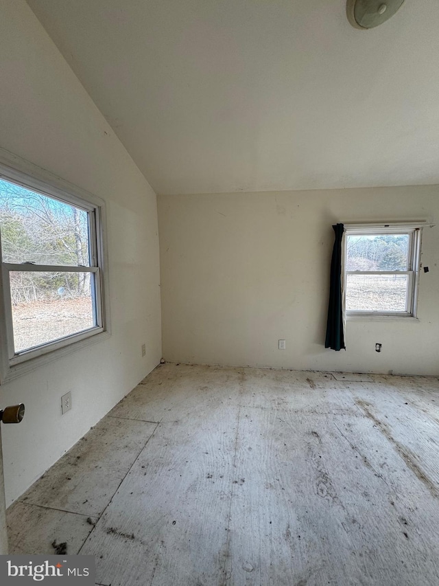 unfurnished room with lofted ceiling