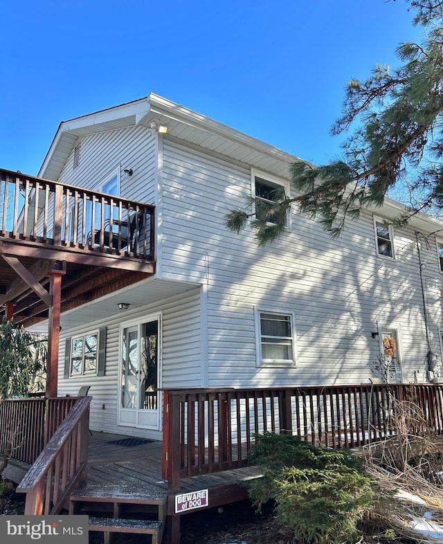 rear view of property featuring a wooden deck