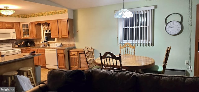 kitchen with sink, decorative light fixtures, baseboard heating, white appliances, and decorative backsplash