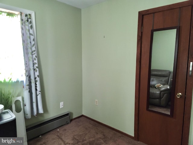 carpeted empty room featuring a baseboard radiator