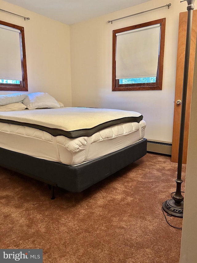 unfurnished bedroom featuring carpet and baseboard heating