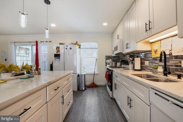 kitchen with white appliances, light stone countertops, sink, and white cabinets