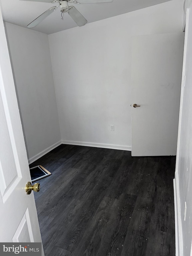 spare room with dark wood-type flooring and ceiling fan