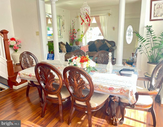 dining space featuring hardwood / wood-style flooring and ornate columns