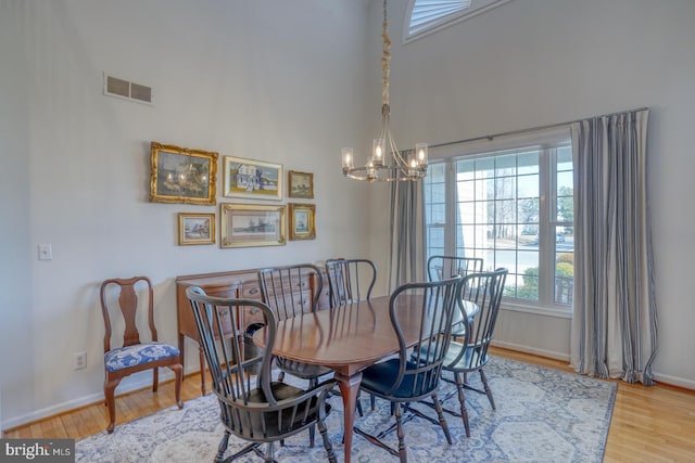 dining space with a chandelier and light wood-type flooring