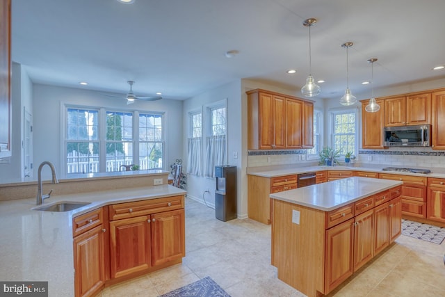 kitchen featuring pendant lighting, sink, backsplash, a center island, and stainless steel appliances