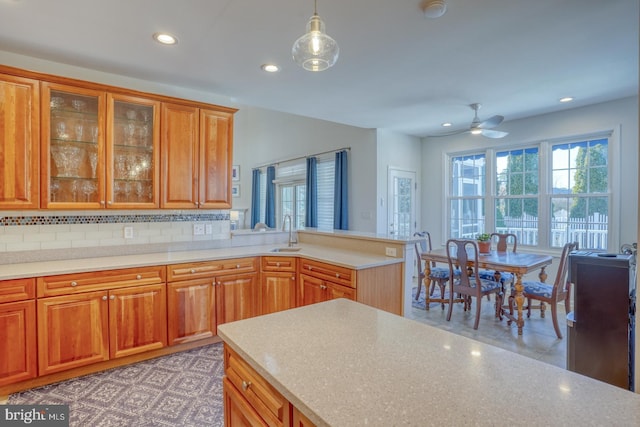 kitchen featuring light tile patterned flooring, decorative light fixtures, tasteful backsplash, sink, and ceiling fan