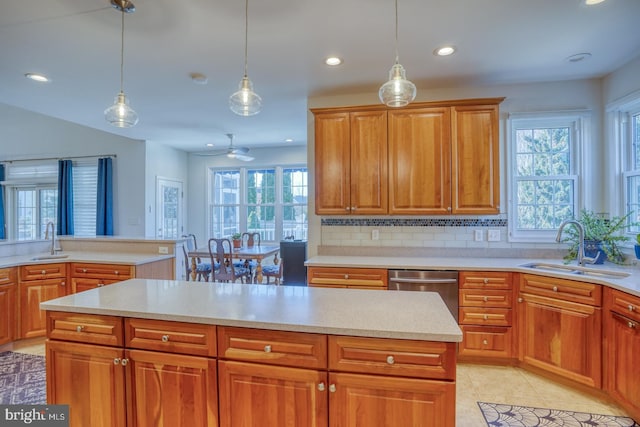 kitchen featuring pendant lighting, sink, dishwasher, backsplash, and light tile patterned flooring