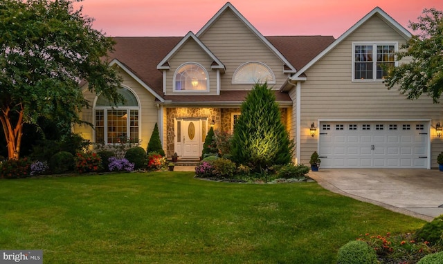 view of front of home with a garage and a yard