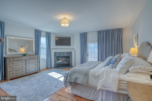 bedroom with a fireplace and light hardwood / wood-style flooring