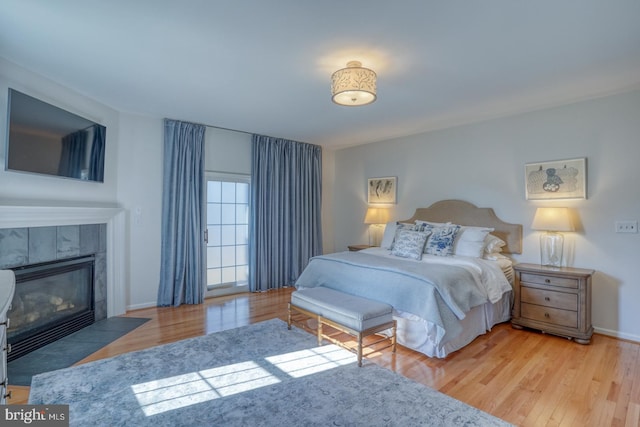 bedroom featuring light hardwood / wood-style flooring and a tile fireplace