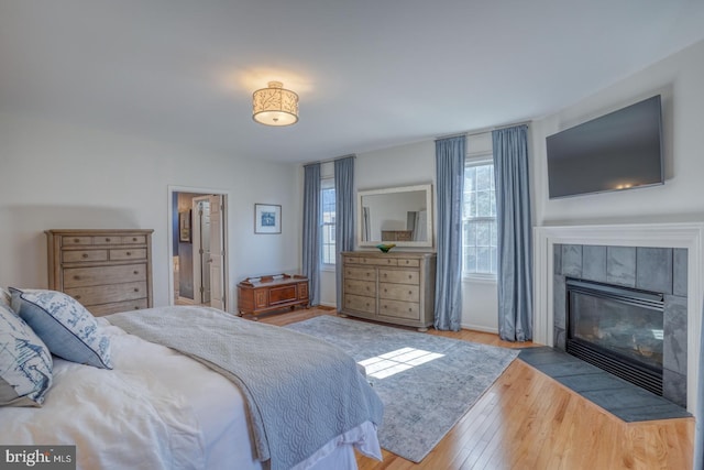 bedroom featuring a fireplace and light hardwood / wood-style flooring