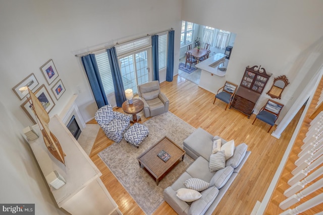 living room with wood-type flooring and a towering ceiling