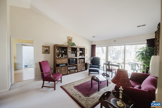 carpeted living room featuring high vaulted ceiling