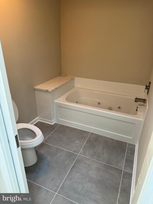 bathroom featuring a bath, tile patterned floors, and toilet