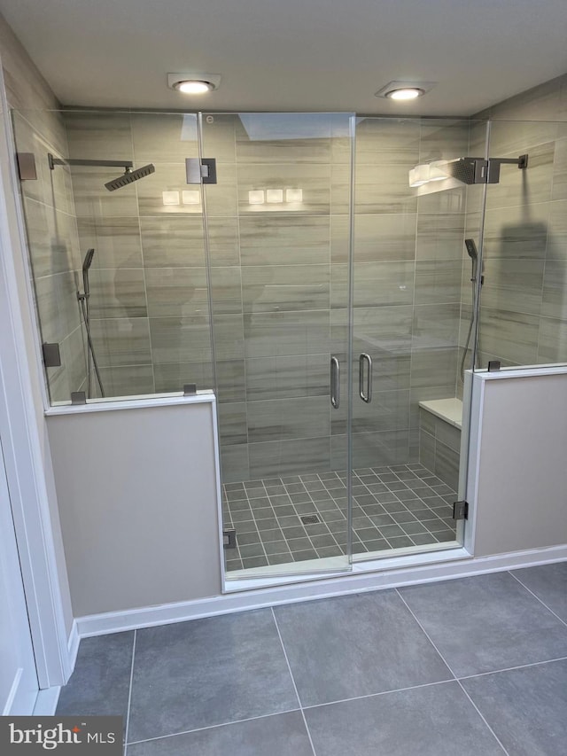 bathroom with a shower with door and tile patterned flooring