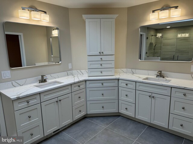 bathroom with tile patterned flooring, vanity, and walk in shower