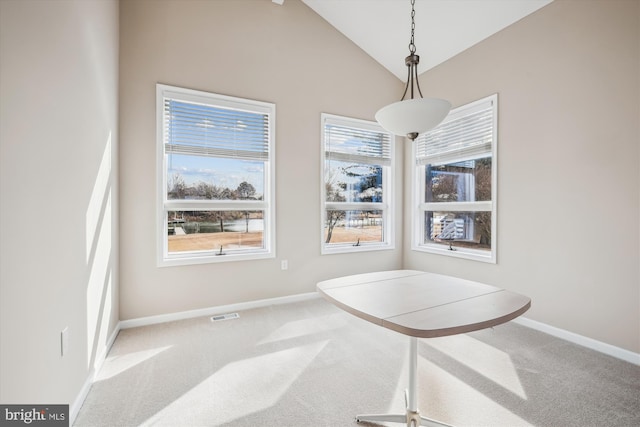 dining room with lofted ceiling and carpet floors