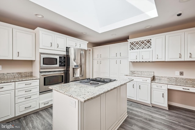 kitchen featuring a kitchen island, white cabinetry, stainless steel appliances, light stone countertops, and light wood-type flooring