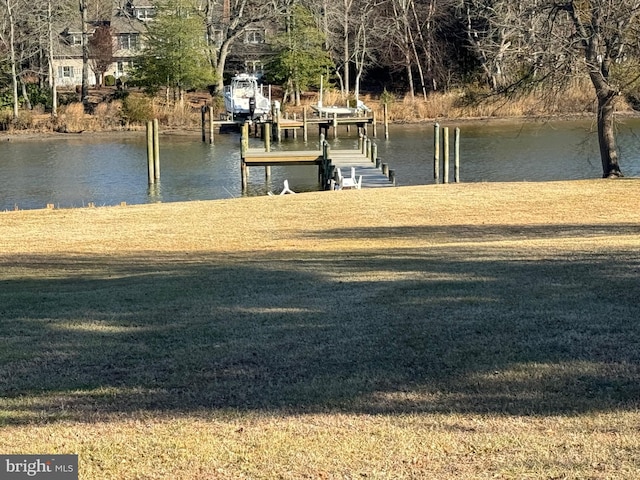 dock area with a lawn and a water view