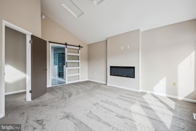 unfurnished living room featuring light carpet, high vaulted ceiling, and a barn door