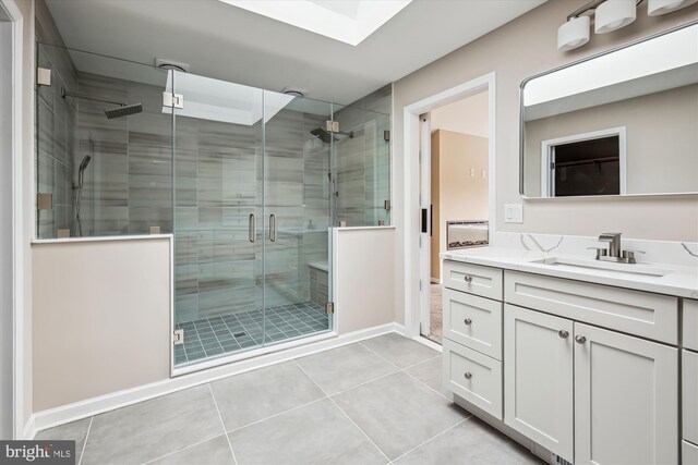 bathroom with an enclosed shower, vanity, and tile patterned floors