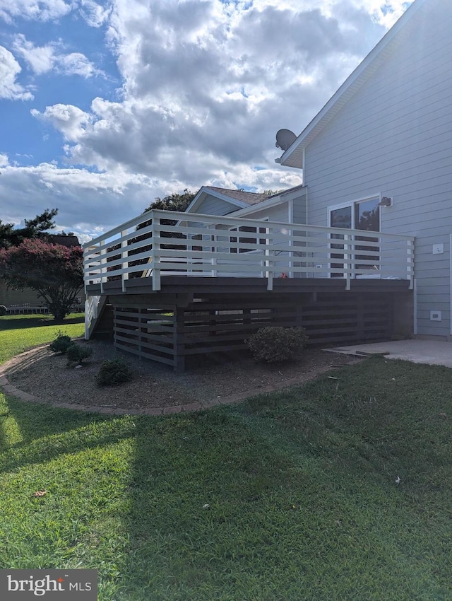 back of house featuring a deck and a lawn