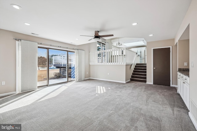 unfurnished living room featuring carpet and ceiling fan