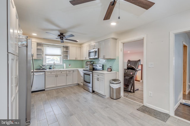 kitchen with sink, appliances with stainless steel finishes, tasteful backsplash, light hardwood / wood-style floors, and white cabinets