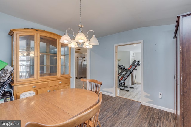 dining room with vaulted ceiling and dark hardwood / wood-style floors