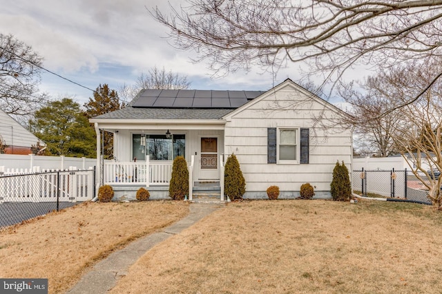 bungalow-style house featuring a front yard, covered porch, and solar panels