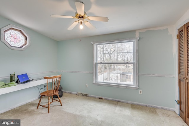 carpeted home office with ceiling fan