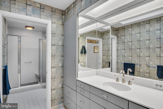 bathroom featuring vanity, tile patterned floors, a shower with door, and tile walls