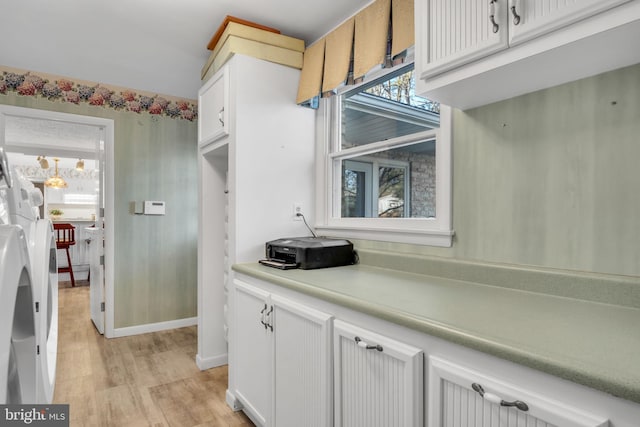 kitchen with light hardwood / wood-style flooring and white cabinets