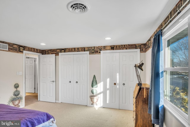 carpeted bedroom featuring multiple closets