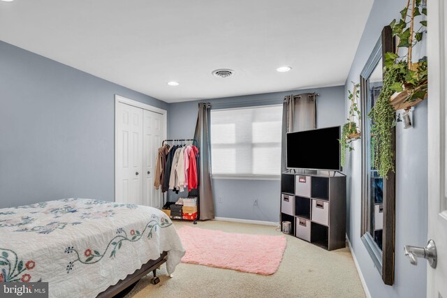 bedroom with light carpet and a closet