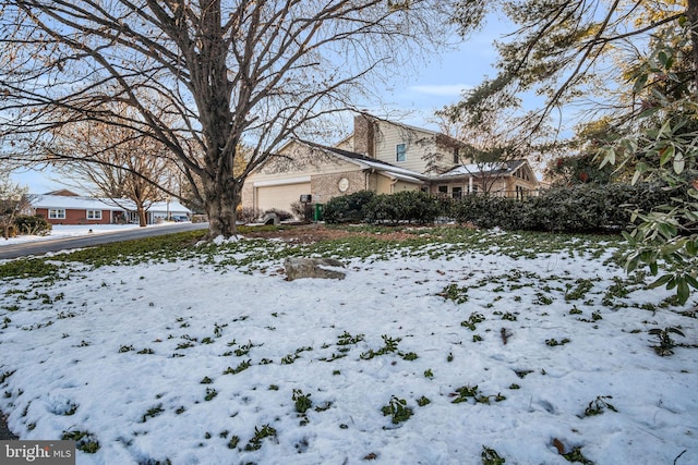 snow covered property featuring a garage