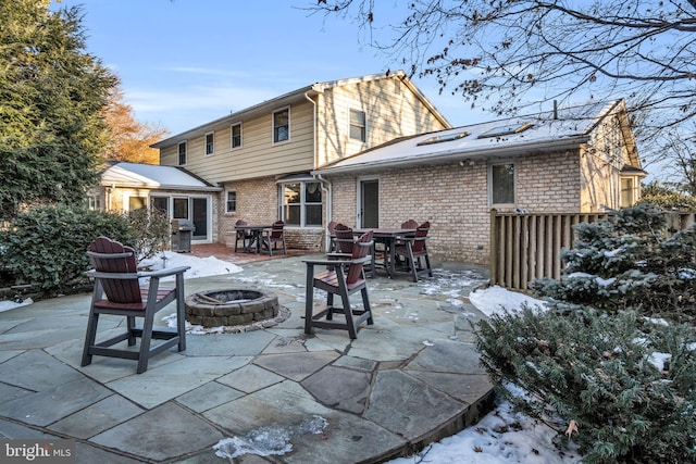 snow covered property featuring a patio area and an outdoor fire pit