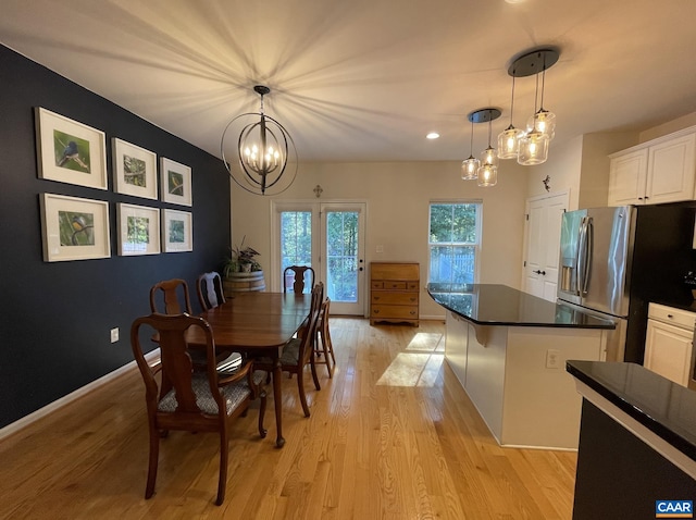 dining space featuring a notable chandelier and light hardwood / wood-style floors