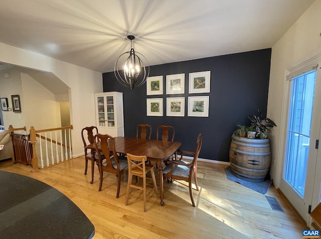 dining space with a notable chandelier and light wood-type flooring