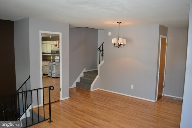 unfurnished room with hardwood / wood-style flooring and a chandelier