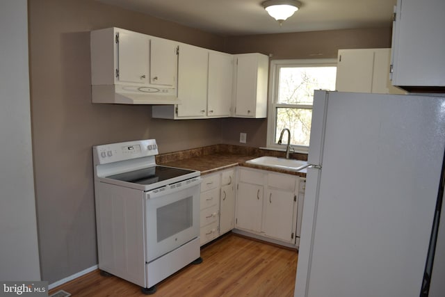 kitchen with sink, white appliances, light hardwood / wood-style flooring, and white cabinets