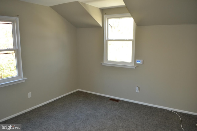 bonus room featuring carpet floors, vaulted ceiling, and plenty of natural light