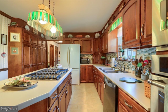 kitchen featuring black dishwasher, sink, hanging light fixtures, white fridge, and stainless steel gas cooktop