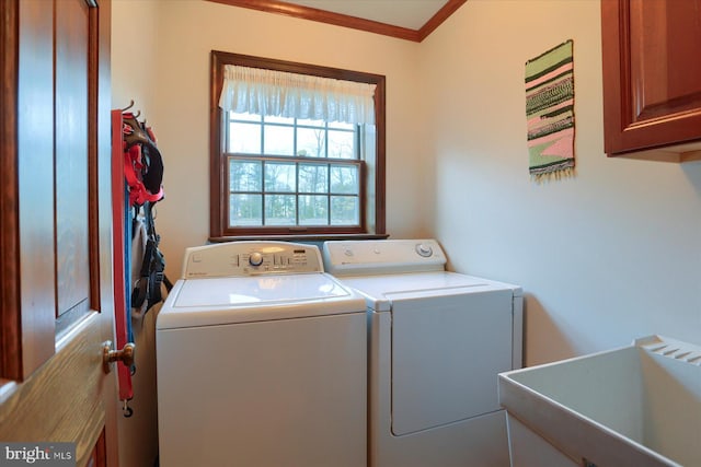 clothes washing area with cabinets, washing machine and dryer, sink, and crown molding