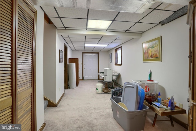 corridor with light colored carpet and a drop ceiling