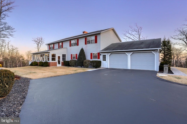 colonial inspired home featuring a garage and covered porch