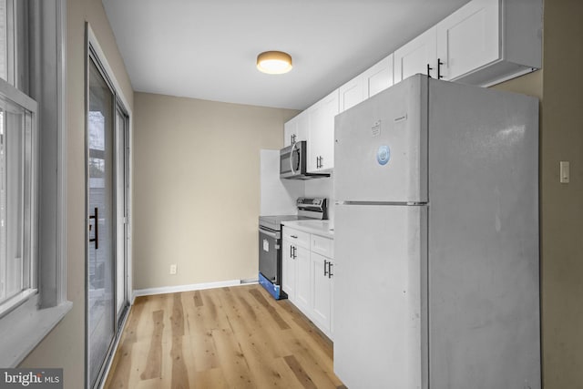 kitchen with white cabinetry, backsplash, light hardwood / wood-style floors, and appliances with stainless steel finishes