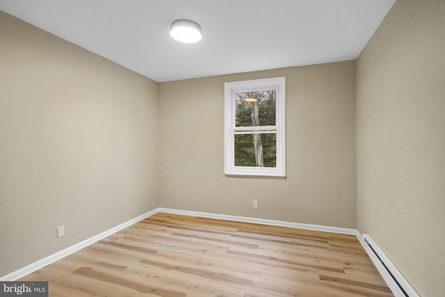 empty room with light hardwood / wood-style flooring and a baseboard heating unit